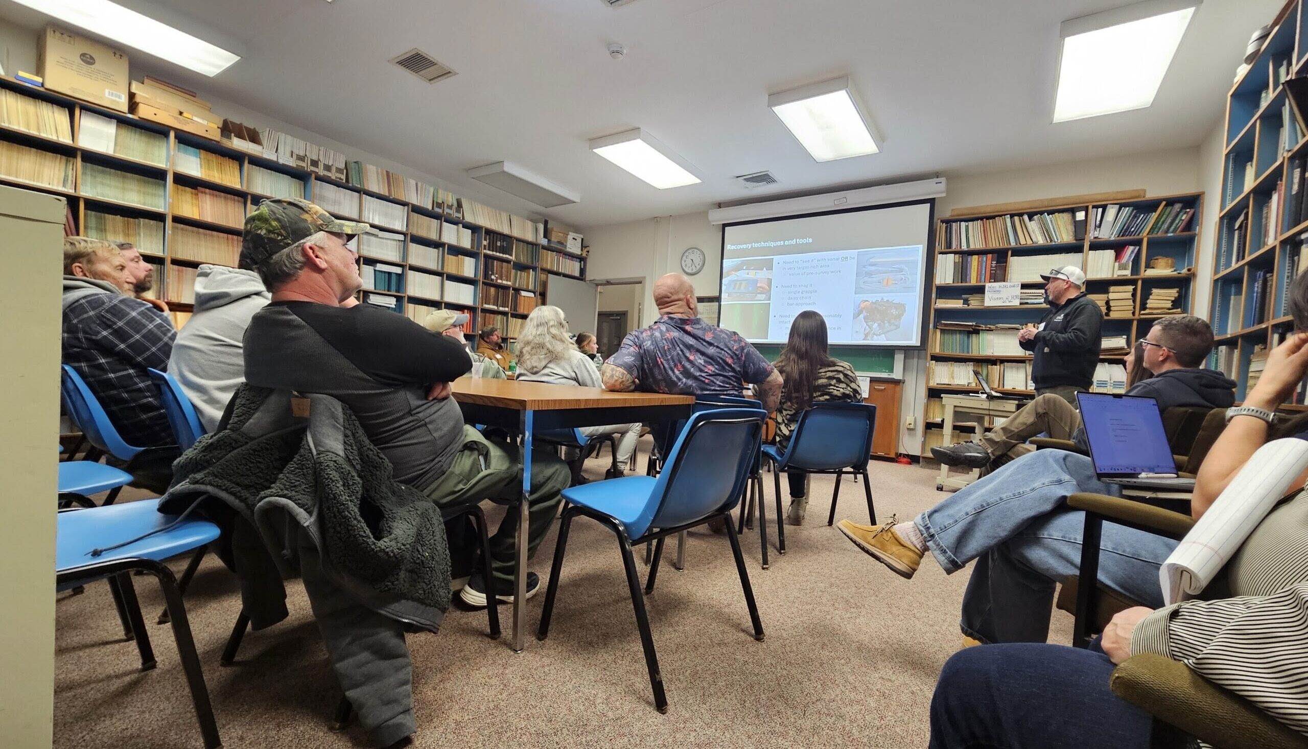 A group of people sitting in a room watching a presentation